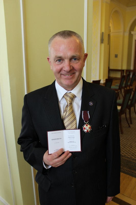 Prezes Roman Soroczyński prezentuje medal i legitymację